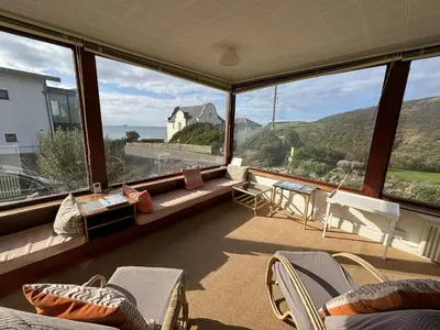 a large room with chairs and a view of the ocean at Cowrie, New Polzeath in Wadebridge