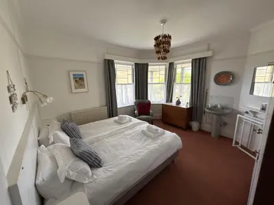 a bedroom with a large white bed with pillows at Cowrie, New Polzeath in Wadebridge