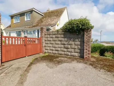 a house with a brick fence and a gate at Pipers in Newquay