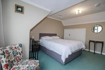 a bedroom with a bed and a chair in it at Pipers in Newquay