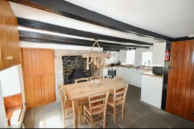 a kitchen with a wooden table and some chairs at Harvest Cottage in Constantine