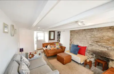 a living room with a couch and a stone wall at Harvest Cottage in Constantine
