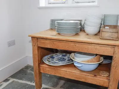 a wooden table with plates and bowls on it at 84 Fore Street in Port Isaac