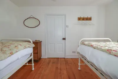 a room with two beds and a mirror on the wall at 84 Fore Street in Port Isaac