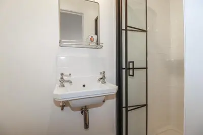 a bathroom with a sink and a mirror and a shower at 84 Fore Street in Port Isaac