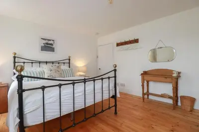 a bedroom with a black bed and a table at 84 Fore Street in Port Isaac