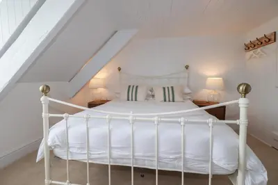a bedroom with a white bed in a attic at 84 Fore Street in Port Isaac