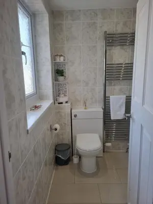 a small bathroom with a toilet and a window at Sandy Paws in Portreath