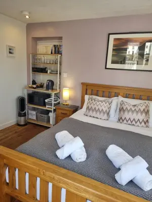 a bedroom with a bed with two towels on it at Sandy Paws in Portreath