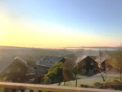 a group of houses in a residential neighborhood with the horizon at Sunrise in Saint Columb Major