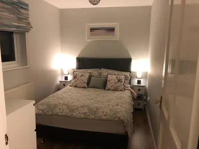 a small bedroom with a bed with two lamps at Sunrise in Saint Columb Major
