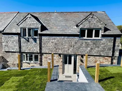a brick house with a white door at Penheyl, Tregonce near Padstow and Sea in St. Issey
