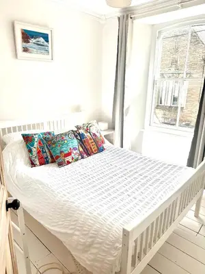 a white bed in a room with a window at Single room, close to beaches and Eden Project in Tywardreath