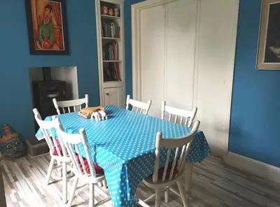 a blue dining room with a table and chairs at Single room, close to beaches and Eden Project in Tywardreath