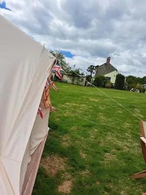 a white tent in a yard with a kite at Bell Tent 2 in St Austell