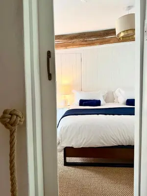 a bedroom with a bed with blue and white pillows at Peaceful Cornish Retreat - Sleeps 6 in Wadebridge