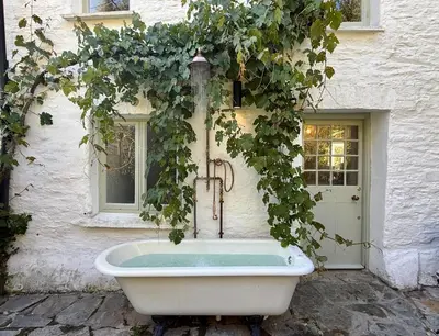 a bath tub sitting outside of a building at Peaceful Cornish Retreat - Sleeps 6 in Wadebridge