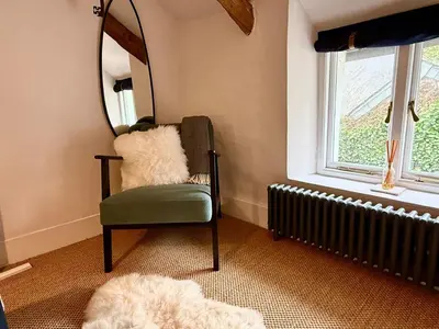 a living room with a chair and a mirror at Peaceful Cornish Retreat - Sleeps 6 in Wadebridge
