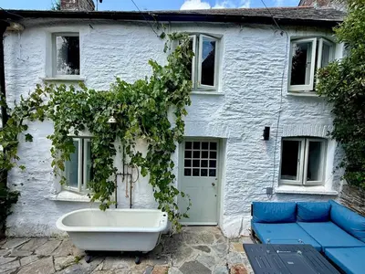 a white house with a bath tub in front of it at Peaceful Cornish Retreat - Sleeps 6 in Wadebridge