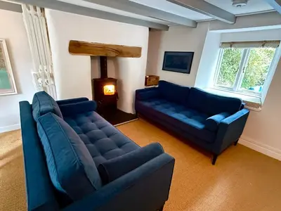 a living room with two blue couches and a fireplace at Peaceful Cornish Retreat - Sleeps 6 in Wadebridge