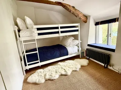 a bedroom with a white bunk bed and a rug at Peaceful Cornish Retreat - Sleeps 6 in Wadebridge
