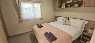 a bedroom with a large bed with towels on it at Emma and Simon's hideaway Retreat in Polperro