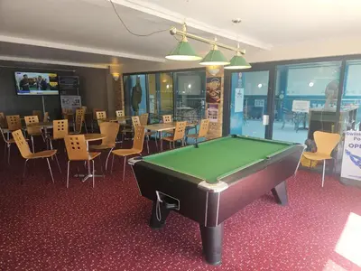 a pool table in a room with tables and chairs at Emma and Simon's hideaway Retreat in Polperro
