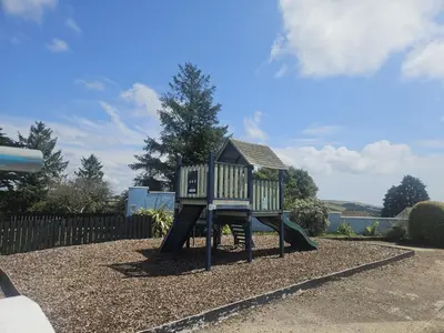 a small playground with a small house on it at Emma and Simon's hideaway Retreat in Polperro
