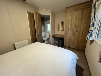 a bedroom with a white bed and a bathroom at Emma and Simon's hideaway Retreat in Polperro