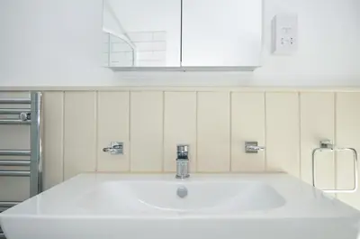 a white sink in a kitchen with a white cabinet at Stargazy in Tintagel