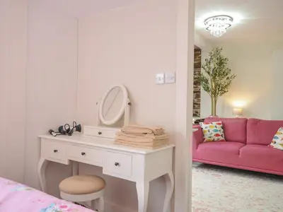 a bedroom with a dressing table and a pink couch at Stargazy in Tintagel