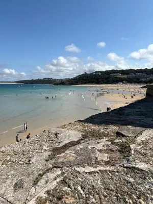 a group of people swimming in the water at a beach at Bagnalls Studio, a newly renovated studio in a traditional fisherman's cottage in St Ives