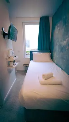 a bedroom with a white bed with a window at The Feather's Hotel Newquay in Newquay