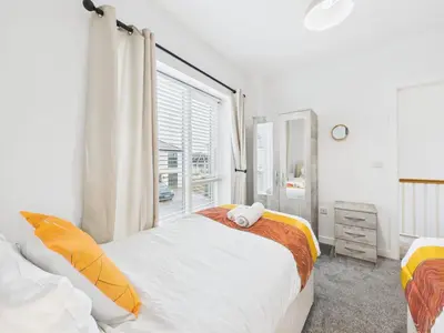 a bedroom with a bed and a window at Beachside Retreat by Signature Stays - Modern Coastal Home in Hayle