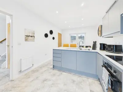 a kitchen with white walls and a blue counter top at Beachside Retreat by Signature Stays - Modern Coastal Home in Hayle