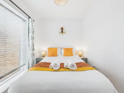 a white bedroom with a bed with towels on it at Beachside Retreat by Signature Stays - Modern Coastal Home in Hayle