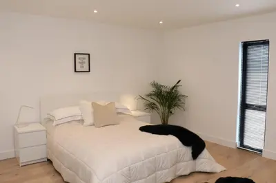 a bedroom with a white bed with a potted plant at The Hidden Sanctuary in Stithians