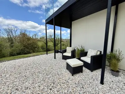 a patio with two chairs and a table at The Hidden Sanctuary in Stithians