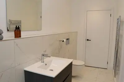 a white bathroom with a sink and a toilet at The Hidden Sanctuary in Stithians