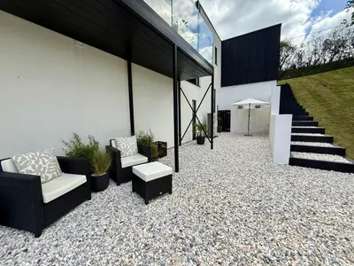 a patio with two chairs and a table and stairs at The Hidden Sanctuary in Stithians