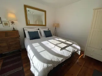 a bedroom with a bed with a mirror on the wall at Central, 10min walk to beach with off-road parking in Falmouth