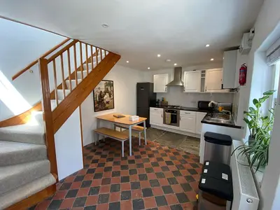 a kitchen with a staircase and a table in a room at Central, 10min walk to beach with off-road parking in Falmouth