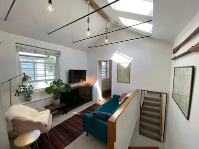 a living room with a blue couch and a staircase at Central, 10min walk to beach with off-road parking in Falmouth