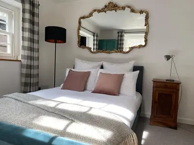 a bedroom with a bed with a mirror on the wall at Central, 10min walk to beach with off-road parking in Falmouth