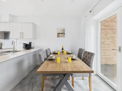 a kitchen with a wooden table and chairs in a kitchen at No4 Harveys Yard By Signature Stays - Luxury Stay - Beach - Parking in Hayle