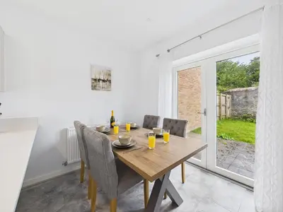 a dining room with a wooden table and chairs at No4 Harveys Yard By Signature Stays - Luxury Stay - Beach - Parking in Hayle