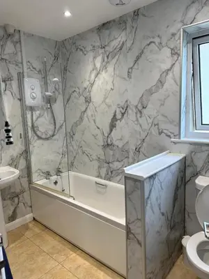a bathroom with a shower and a tub and a sink at Bungalow with stunning views over Widemouth Bay in Widemouth Bay