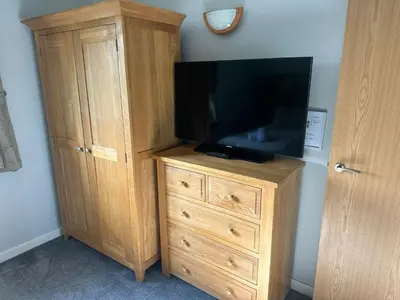 a wooden cabinet with a television on top of it at 5A Retallack Resort & Spa in Saint Columb Major