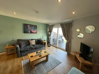 a living room with a couch and a tv at 5A Retallack Resort & Spa in Saint Columb Major