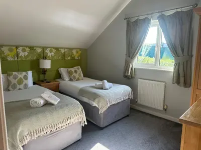 a bedroom with two beds and a window at 5A Retallack Resort & Spa in Saint Columb Major